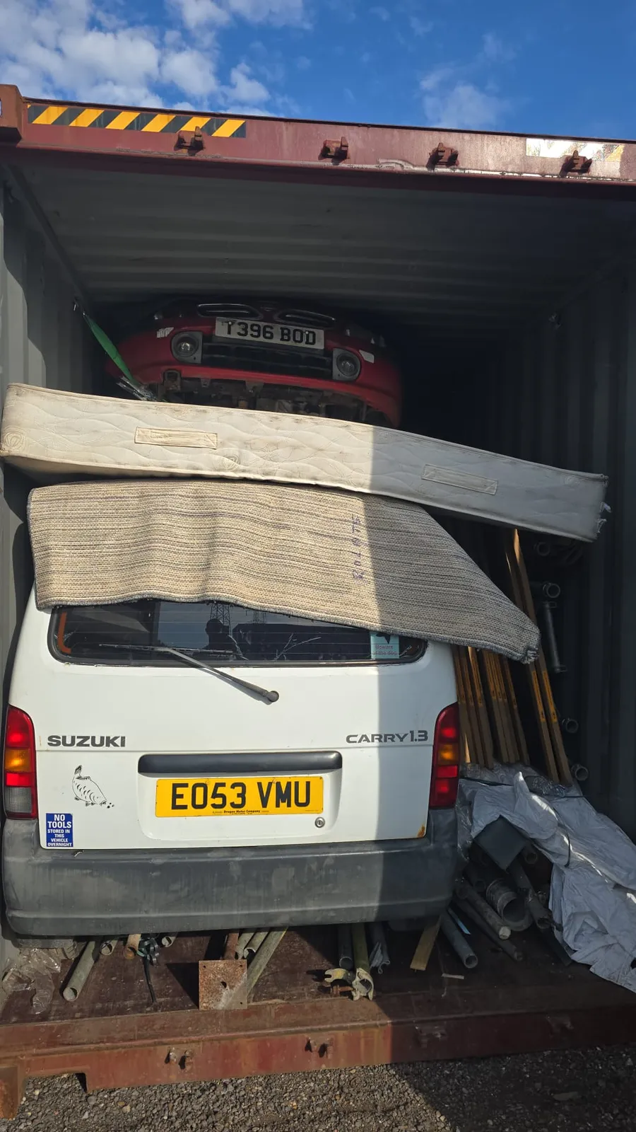 Car and Suzuki van loaded and secured inside a shipping container for door-to-door shipping from the UK to Africa