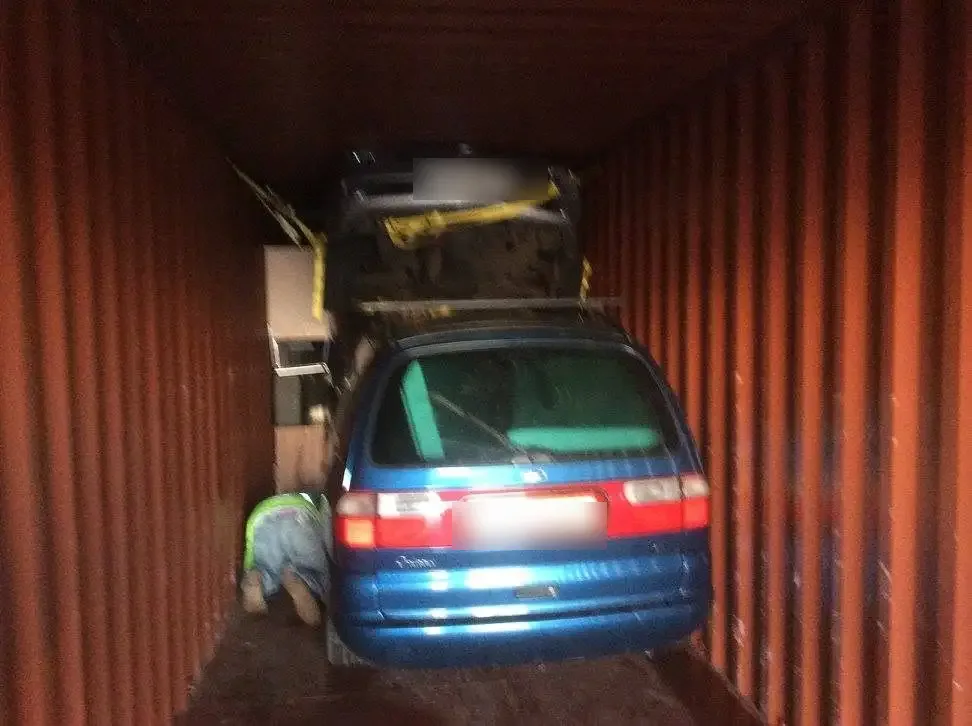 Two vehicles stacked and secured inside a shipping container bound for Africa
