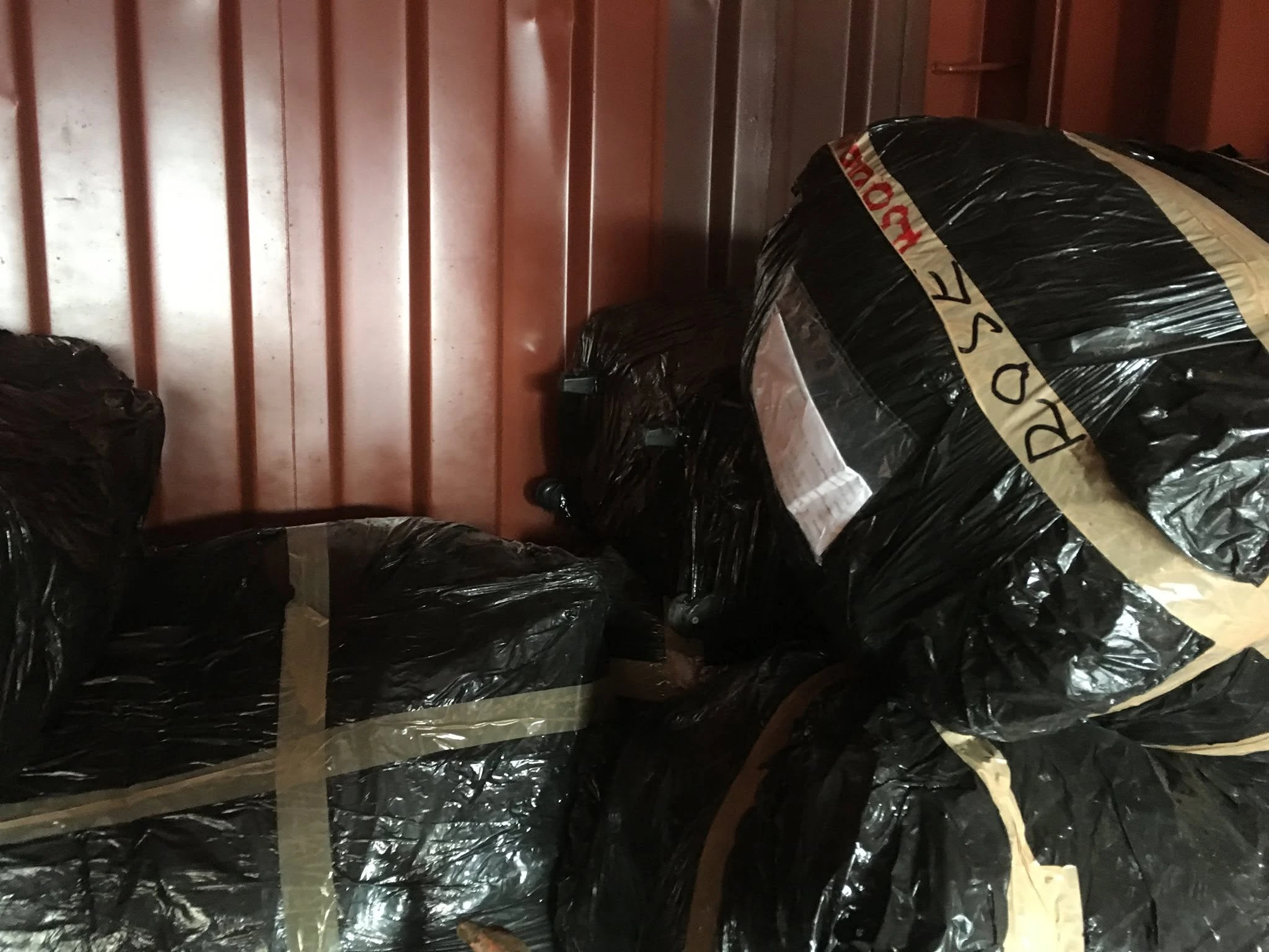 Wrapped and labelled cargo bales loaded inside a shipping container to Africa